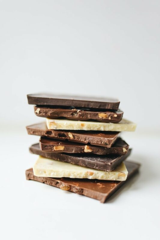 carrés des trois chocolat en pile sur fond blanc - Photo de Polina Tankilevitch provenant de Pexels