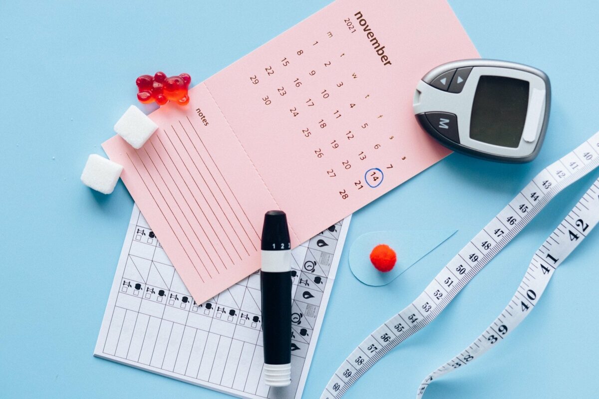 calendrier, capteur de glycémie, mètre et bonbons sur fond bleu