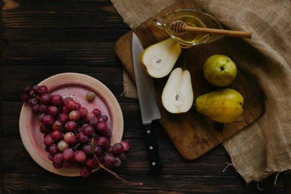 poires, raisins noirs et couteau