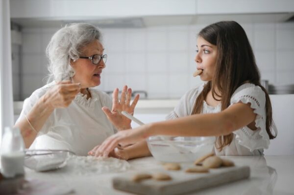 grand-mère et petite-fille habillées en blanc cuisinent