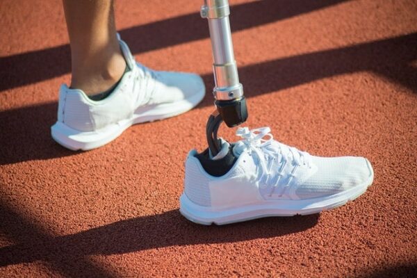 pied amputé dans baskets blanche sur piste athlétisme