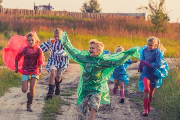 enfants qui courrent dehors avec imperméables