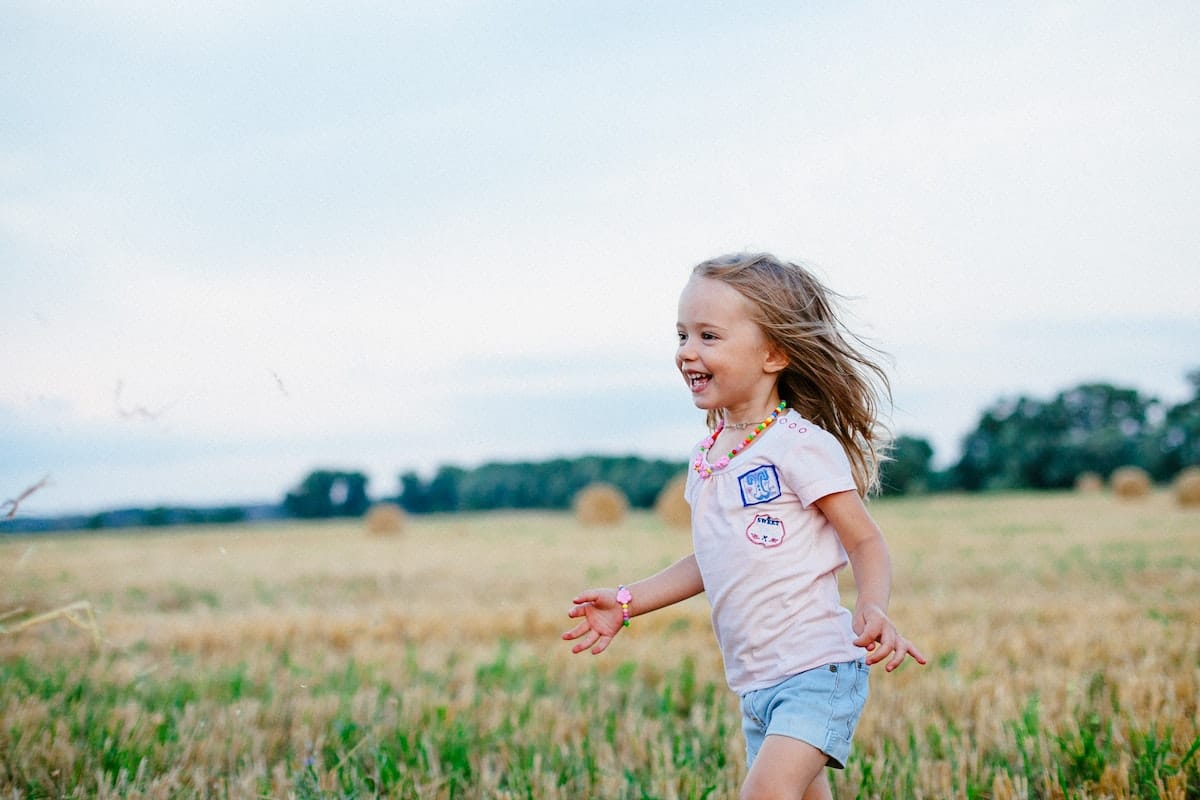 enfant fille souriante dans un champ - Photo de Pixabay