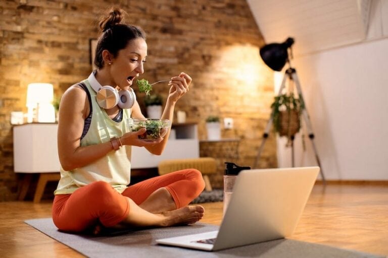 Femme sportive assise qui mange une salade - Freepik