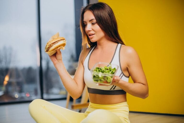 femme sportive qui mange burger ou salade