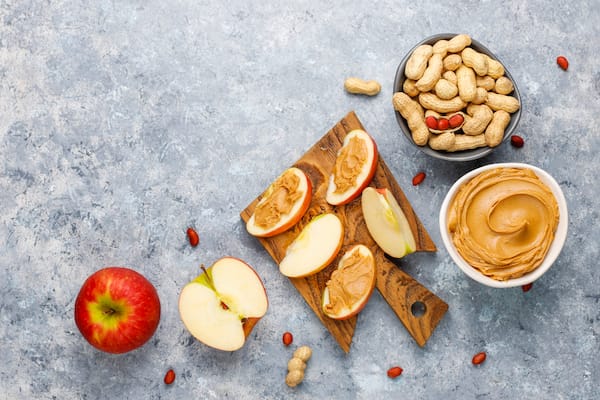 pomme et beurre de cacahuète sur fond gris - Freepik